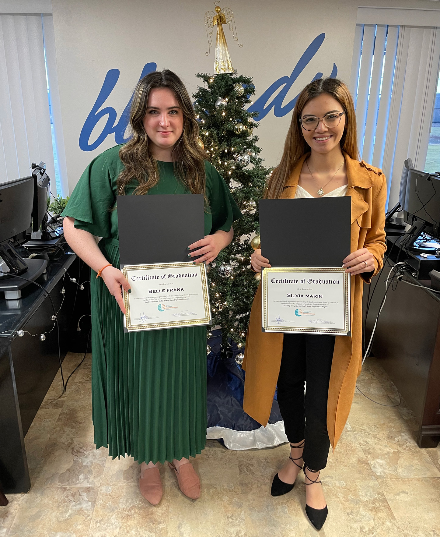 Belle and Silvia holding certificates from the Leadership Orange YP Program