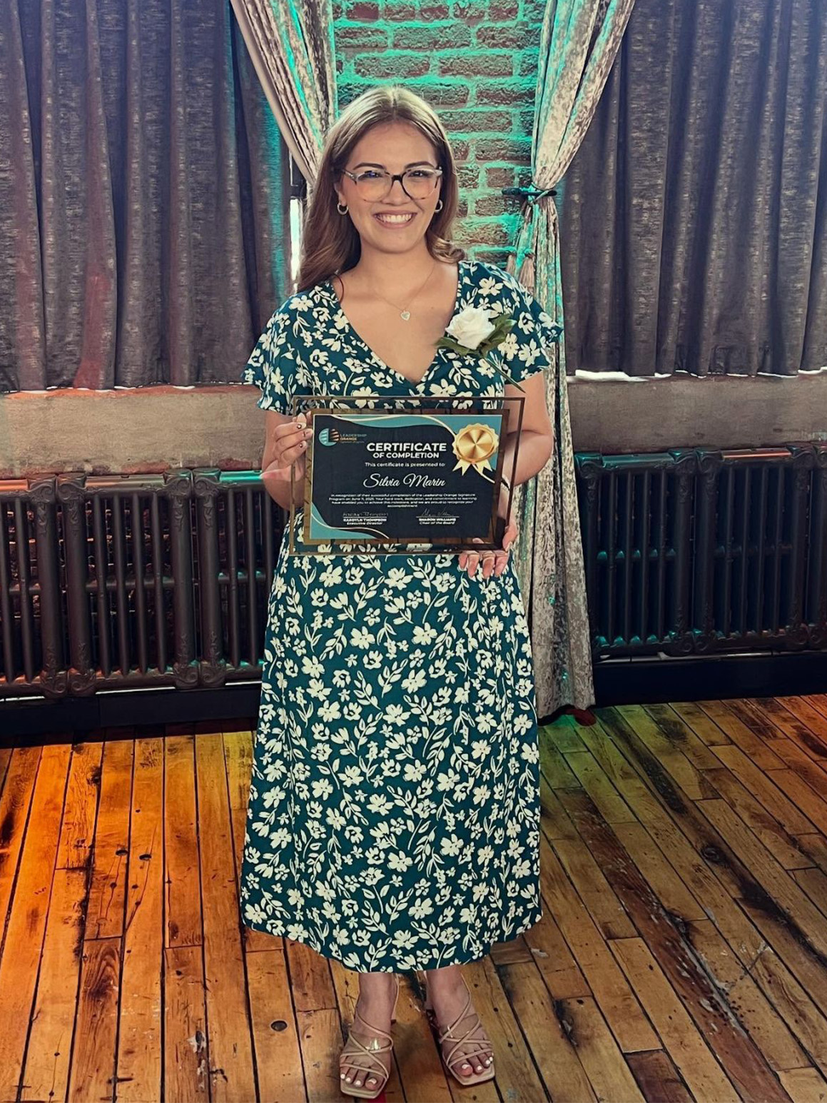 Silvia holding her certificate from Leadership Orange 2025 Graduation